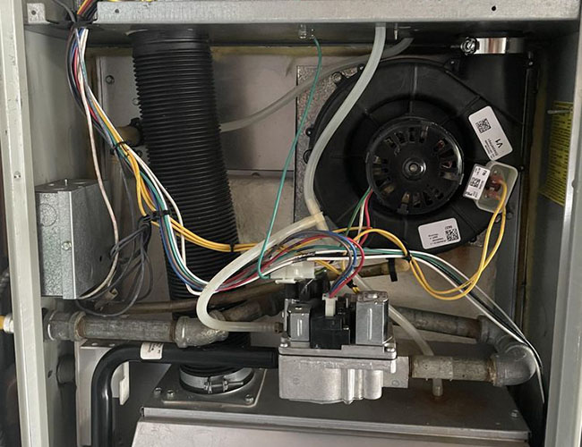 Inside view of a machine showing wires, a motor, and other components, with a focus on the organized layout of the internal parts.